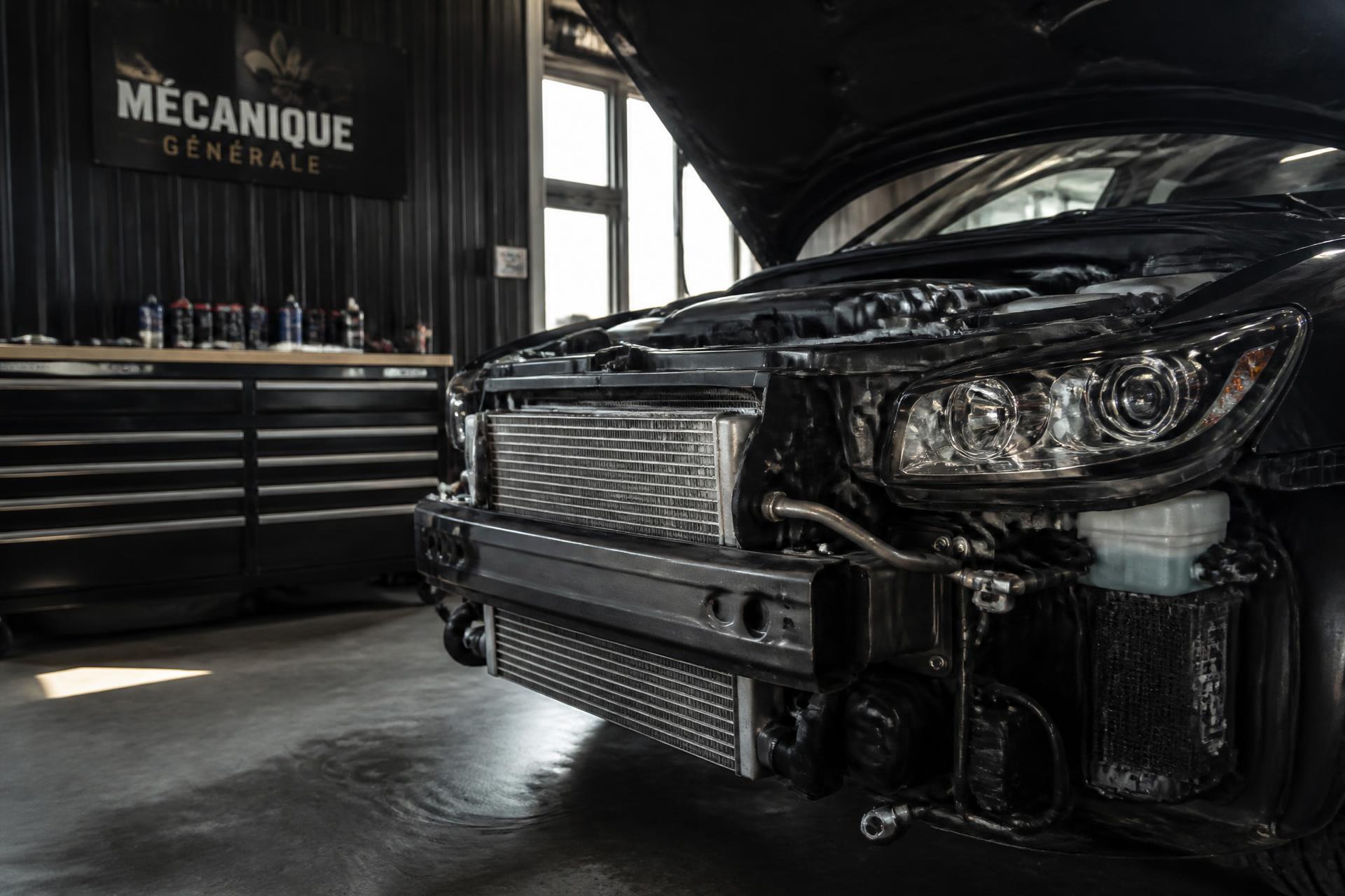 Atelier automobile propre avec véhicule capot ouvert et radiateur visible